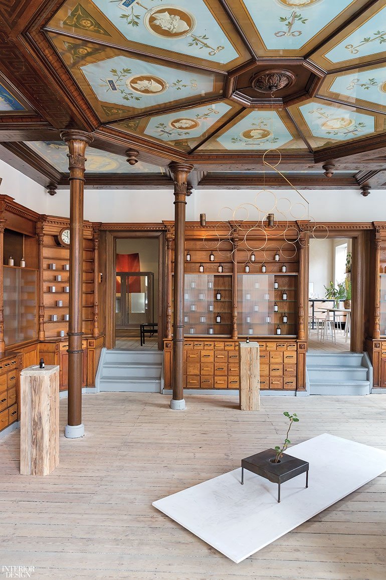 A historic room with a hexagon design on the ceiling and wood built-in retail shelves