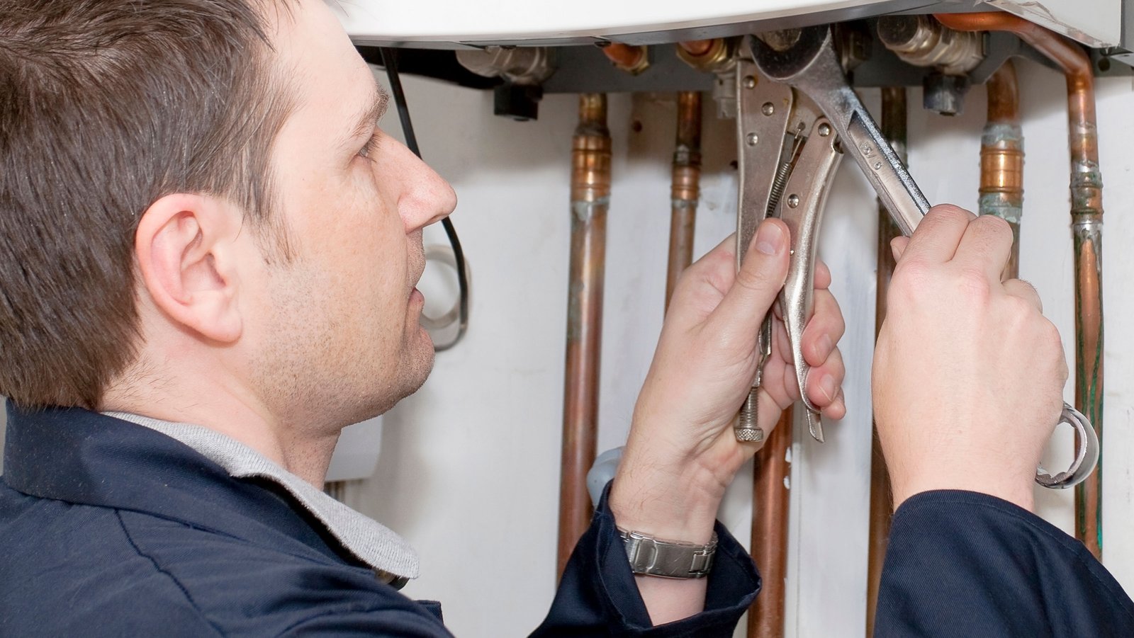 Plumber at work on a water boiler