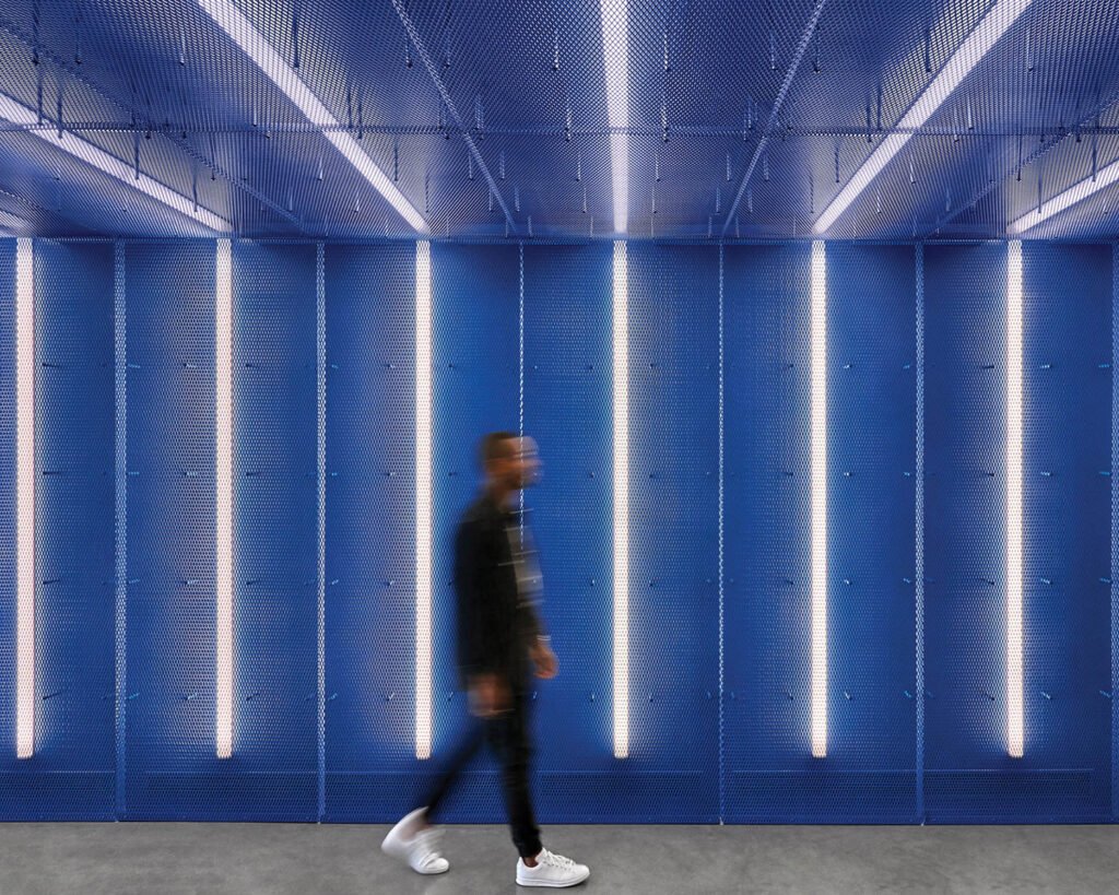 a blue hallway with vertical LED lights at Adidas