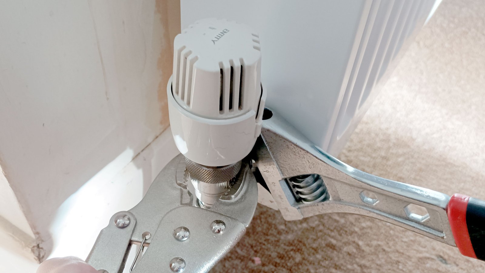 Grips and adjustable spanner tightening TRV onto radiator