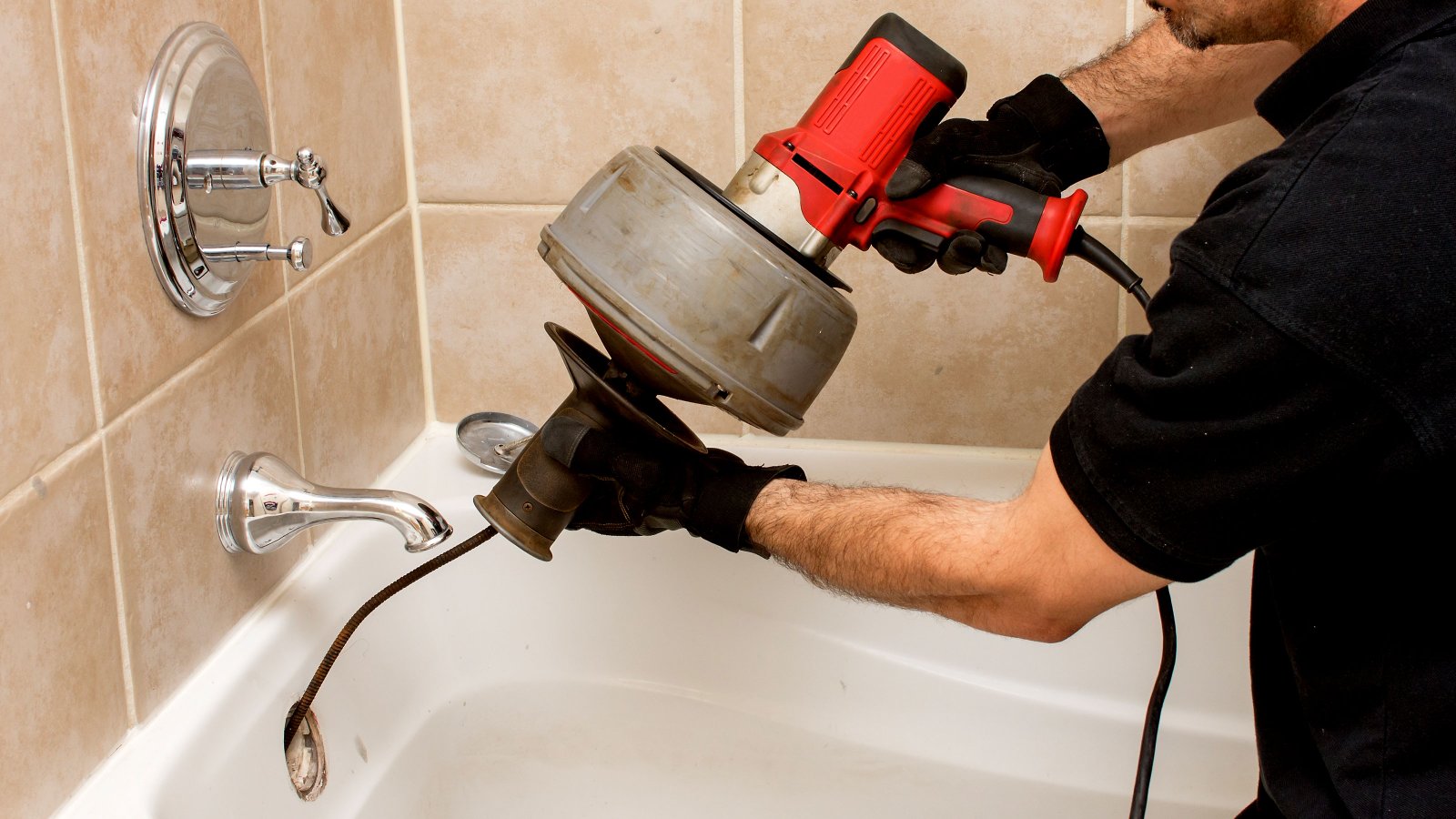 Powered drain snake clearing bath blockage