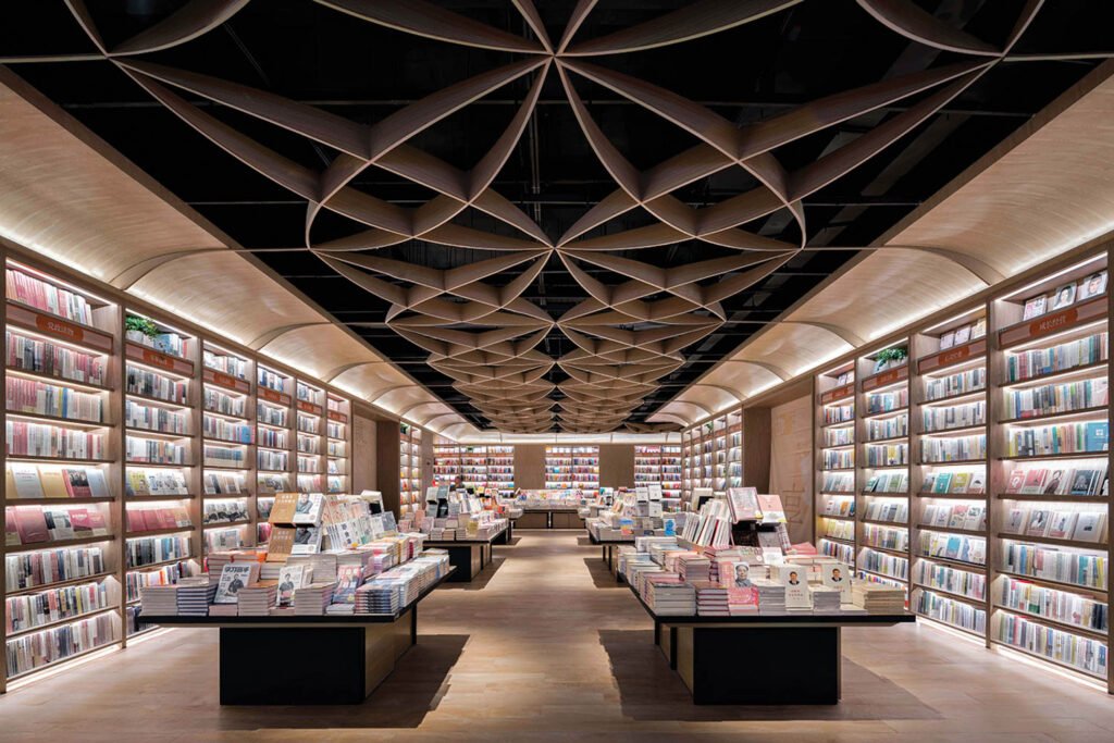 a book display with a dark ceiling featuring a curved pattern