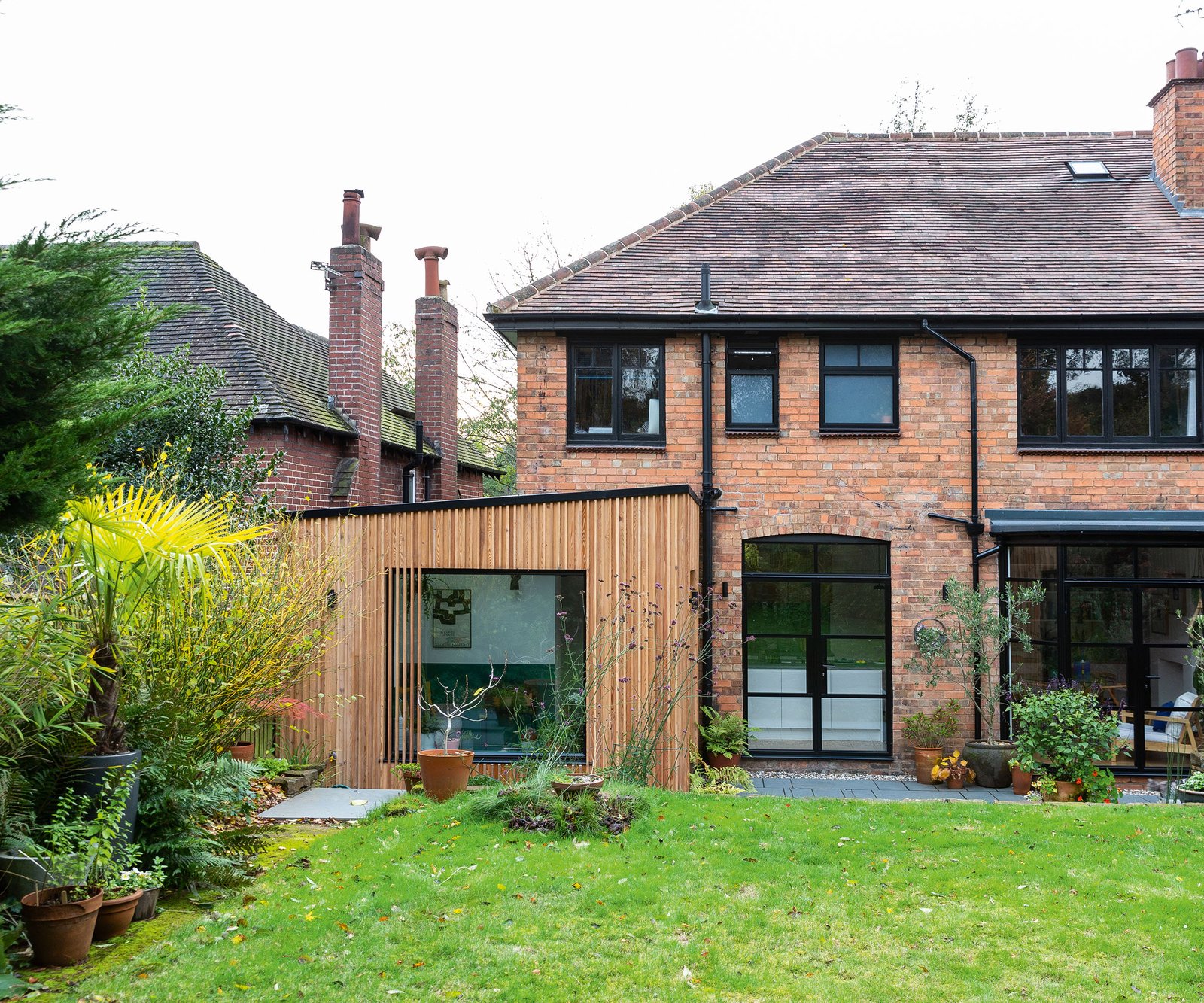 Slightly uneven but lush green lawn at the back of a newly renovated home