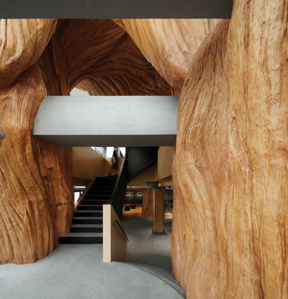 a custom fiber reinforced–plastic sculpture in the form of an enormous tree trunk at the entrance of Arc'teryx in Beijing