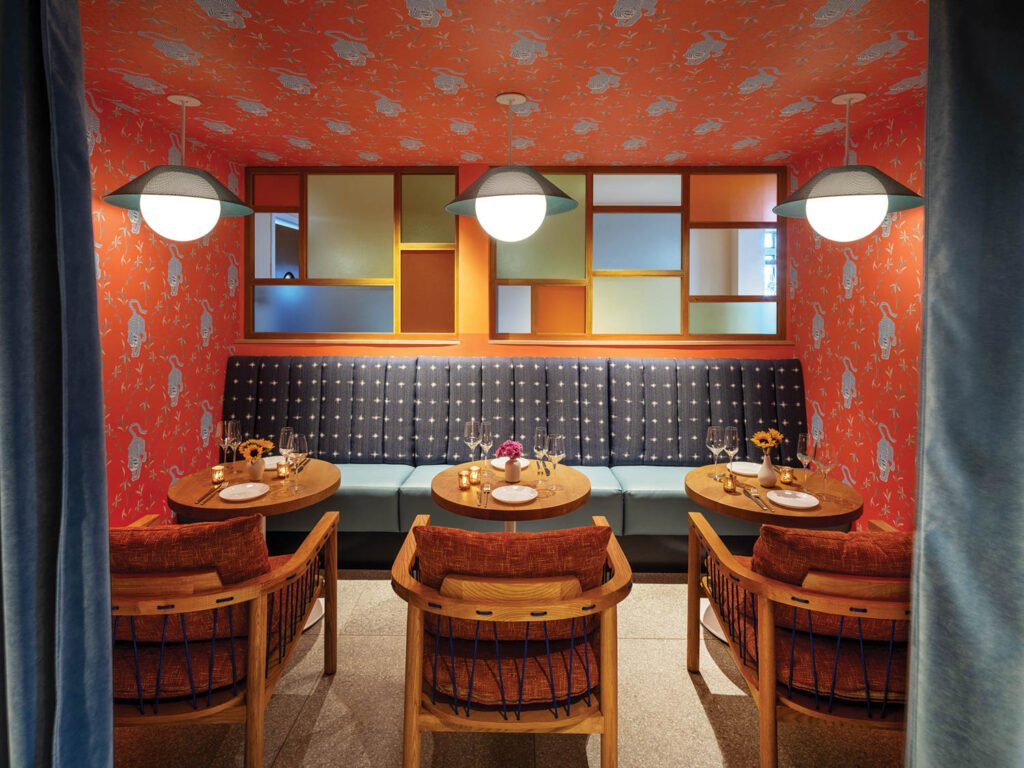 dining area with bright red patterned ceiling, booth and intimate seating
