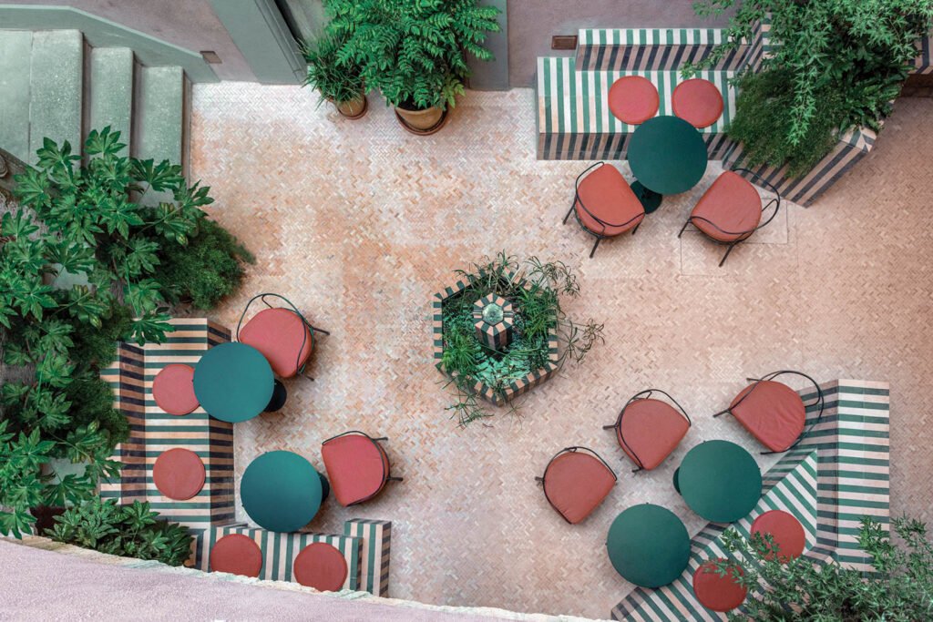 aerial view of courtyard with green tables and red chairs