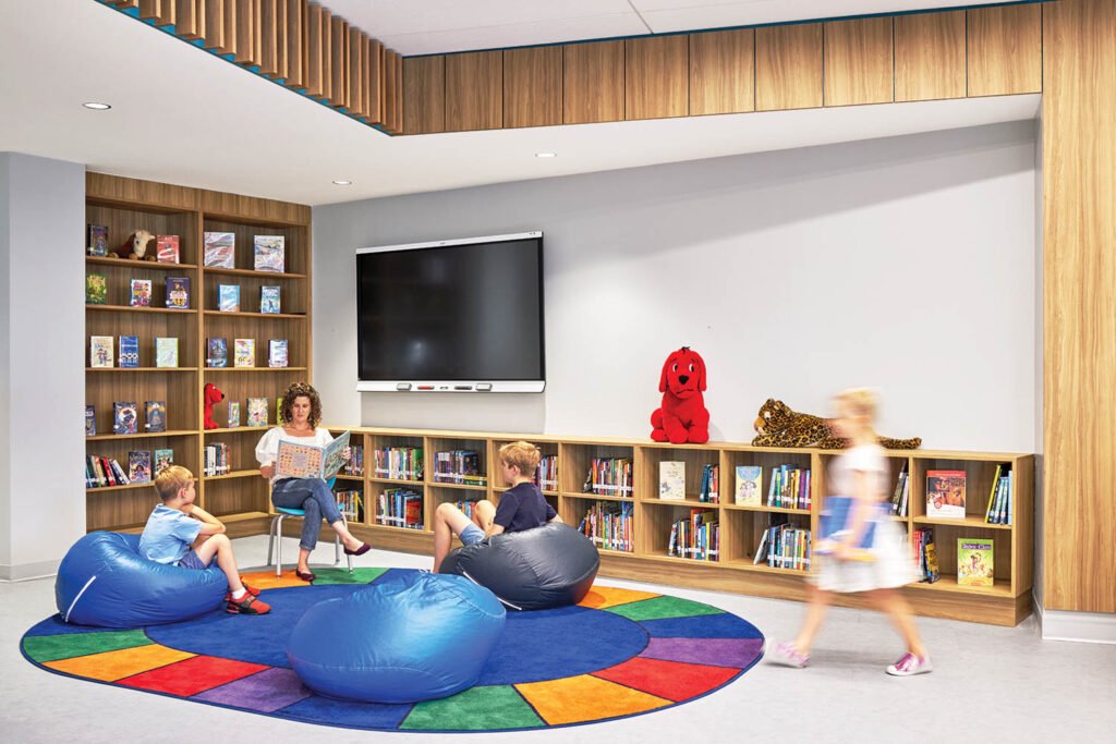 a library and reading area with a rainbow colored rug