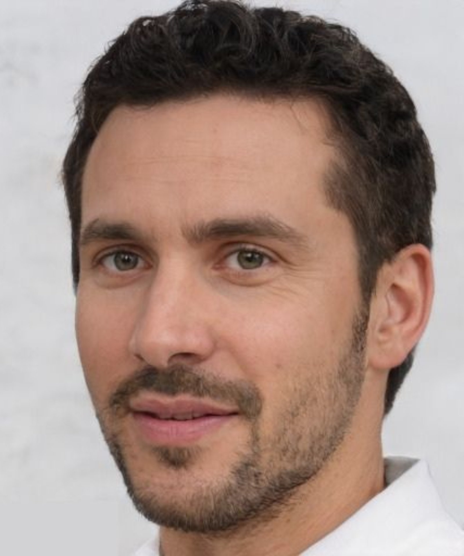 headshot of male with dark hair and facial hair