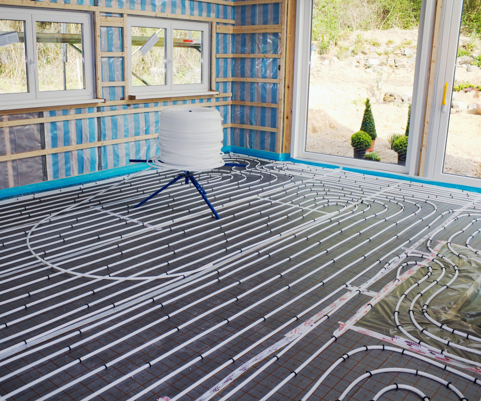 wet underfloor pipes being laid in room