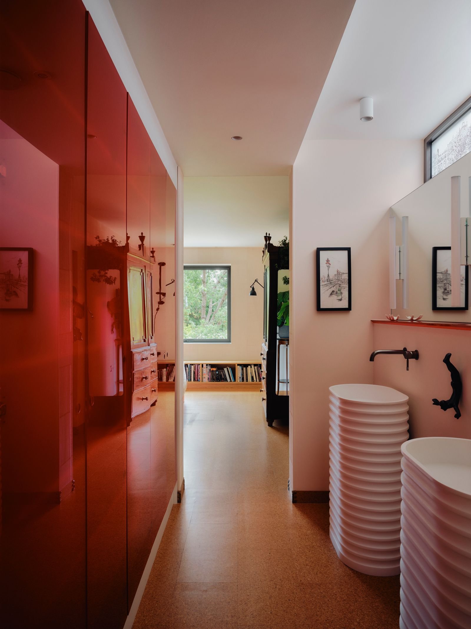 Red Perspex panels conceal walltowall bathroom storage in Clare Gaskins London home.