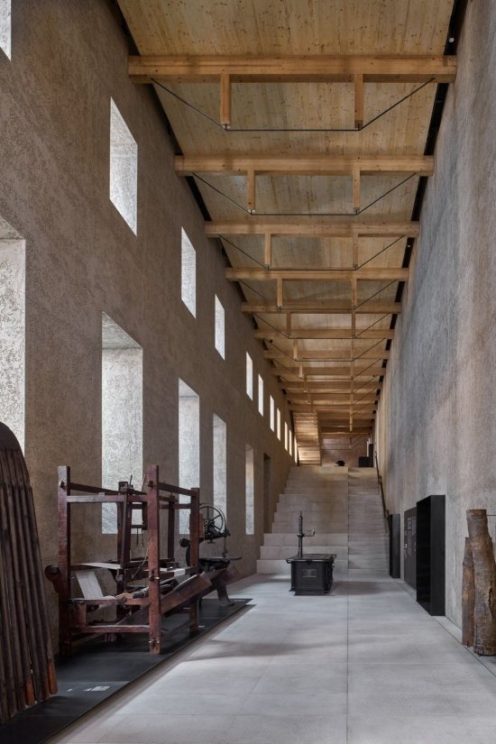 Exhibition space beneath the timber volume