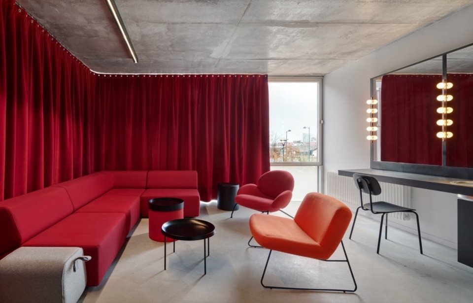 A lounge framed by red curtains