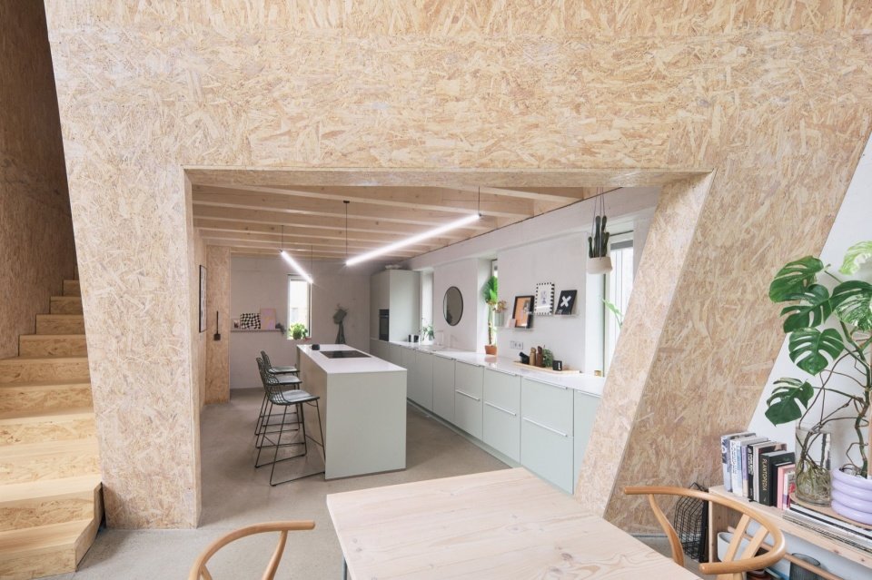 The inclined timber wall organizes the interior